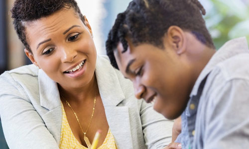 Photo of a woman talking to a male teenager.